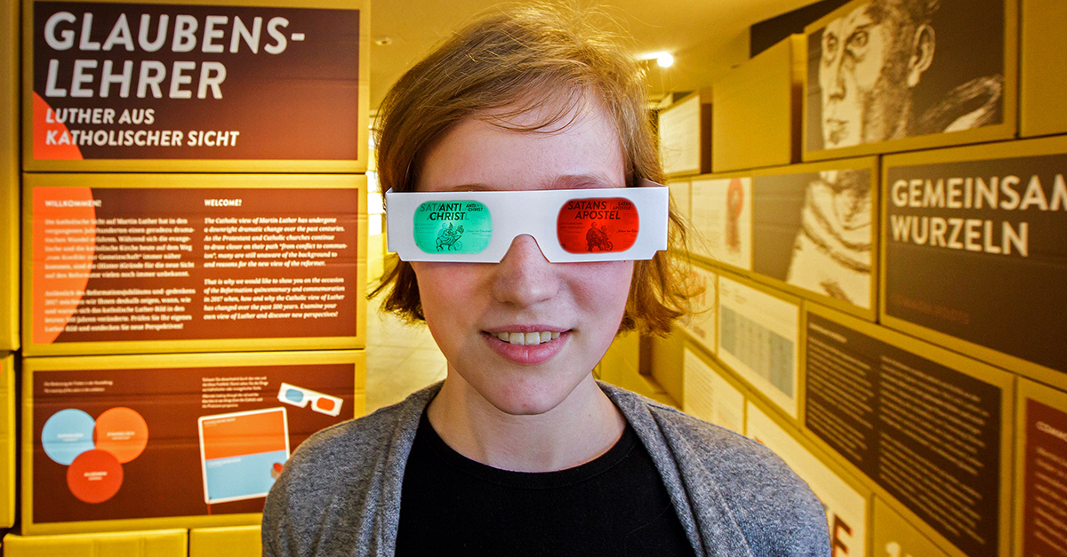 Eine Frau trägt eine zweifarbige Brille in der Ausstellung des Lutherhauses Eisenach